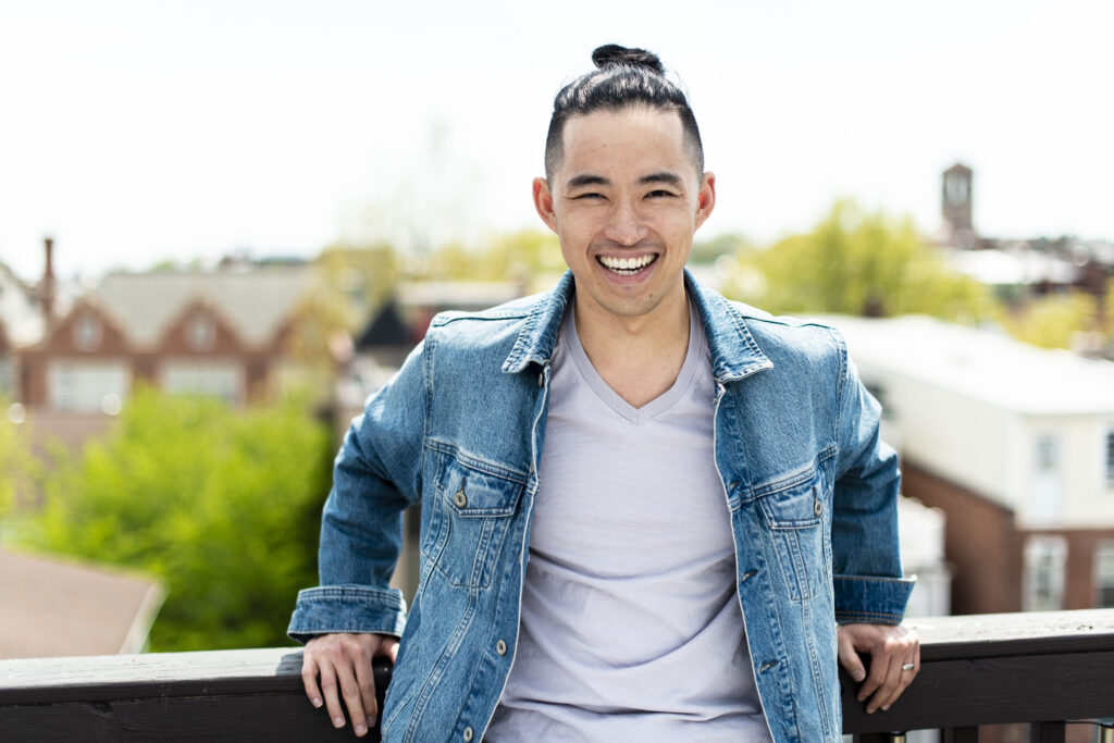 photo of author Patrick J. Zhou smiling and leaning casually against a railing.